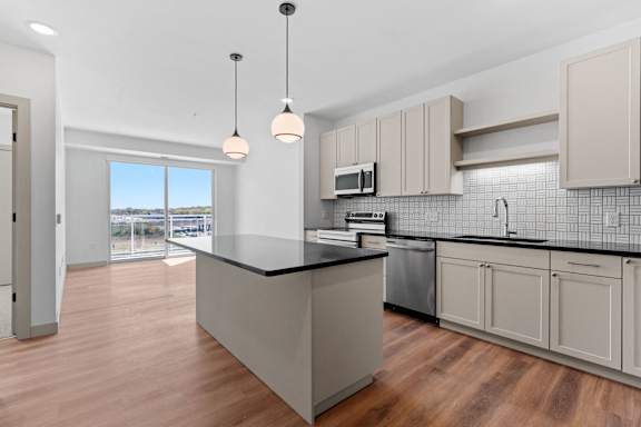 a large kitchen with an island and a large window at The Mera, St Louis Park, MN