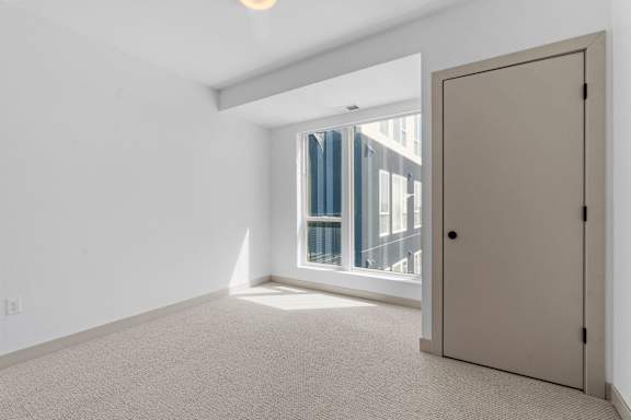 a living room with a large window and a door at The Mera, St Louis Park Minnesota