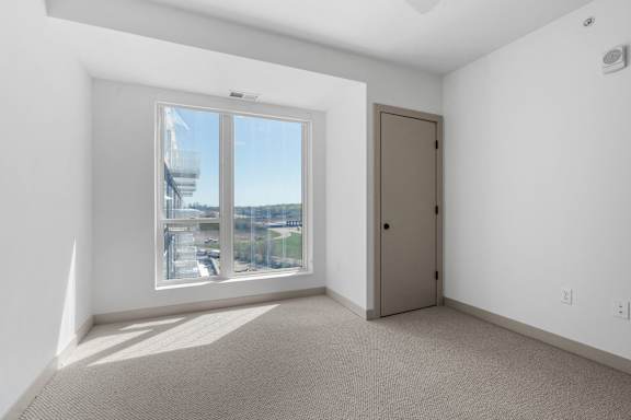 a living room with a large window and a door at The Mera, St Louis Park Minnesota