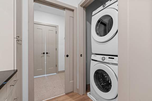 a white washer and dryer in a laundry room with a door at The Mera, St Louis Park