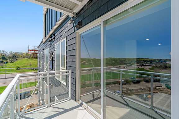 a balcony with glass doors and a view of a field at The Mera, Minnesota