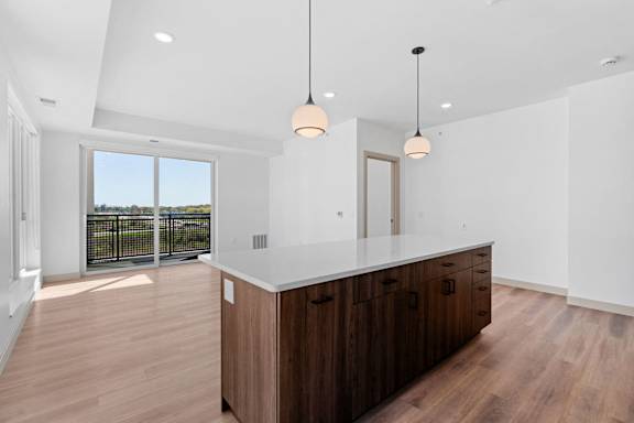 a kitchen with a large island and a balcony at The Mera, St Louis Park