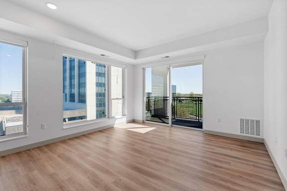 a living room with a hard wood floor and large windows at The Mera, St Louis Park