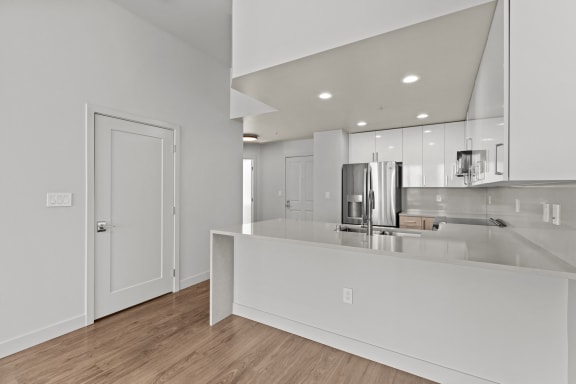 a kitchen with a large island and a door to the living room