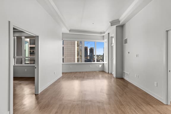 a living room with white walls and a large window