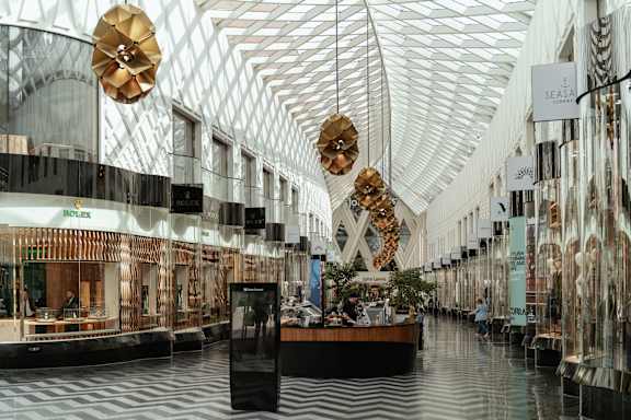 A large atrium with a glass ceiling and a long table with people sitting around it.