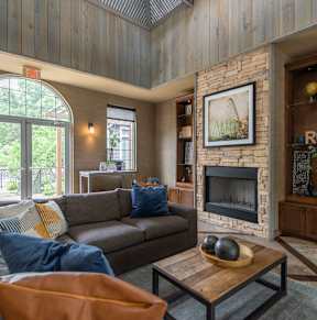 A living room with a grey couch and a fireplace.