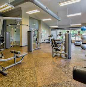 A gym with a variety of equipment including weights and machines.