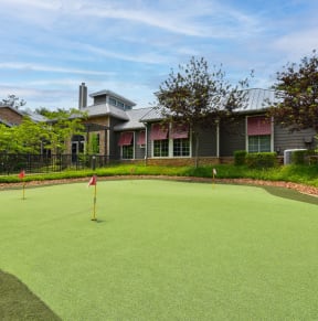 a putting green with houses in the background at Riverset Apartments, Memphis, 38103