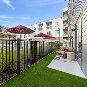 A patio with a pool and a black fence.