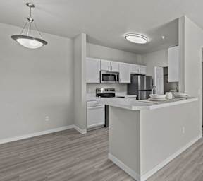 A modern kitchen with white appliances and cabinets.