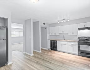 a renovated kitchen with white cabinets and black appliances at Uphill Flats, Decatur, GA