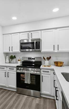 A kitchen with a bowl of Brussels sprouts on the counter.