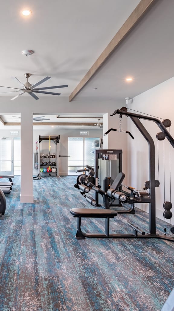 a gym with treadmills and other exercise equipment in a building with large windows
