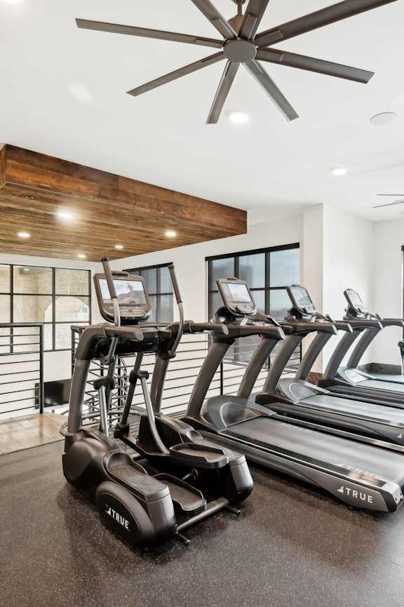 A spacious gym with wooden floors and various exercise equipment.