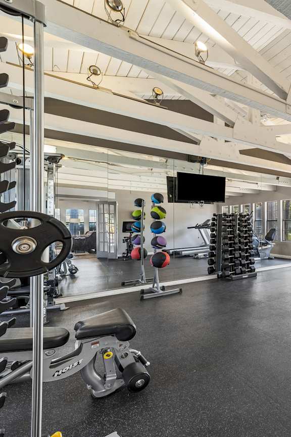 a gym with weights and cardio machines in it