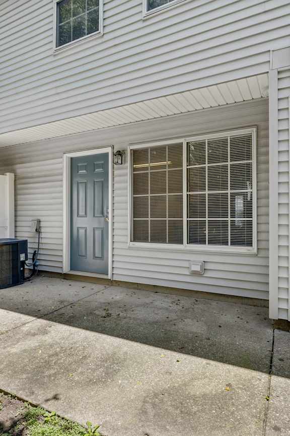 A house with a blue door and a tree in front.