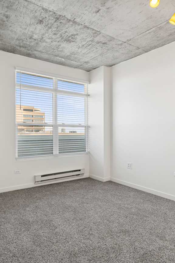 A room with a window and a fire extinguisher on the wall.