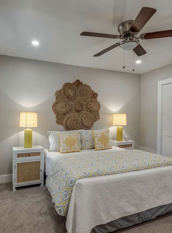 a bedroom with a large bed and a ceiling fan