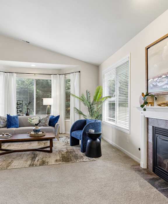 A living room with a fireplace and a painting on the wall.