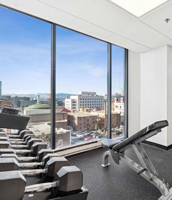 A gym with a view of the city outside the window.