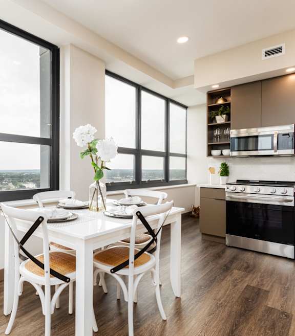 A modern kitchen with a white chair and stainless steel appliances.