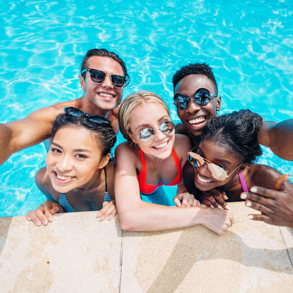 A group of friends taking a selfie in a swimming pool.