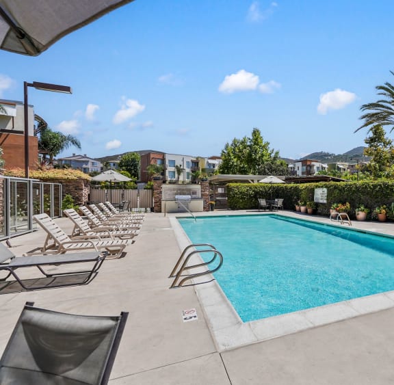 a swimming pool with lounge chairs and palm trees