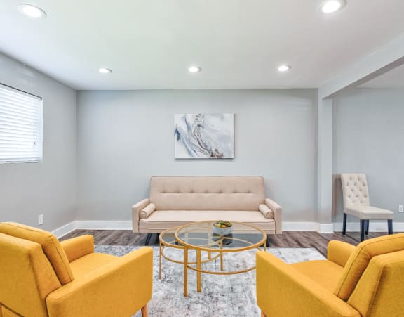 a living room with couches and chairs and a glass coffee table at Uphill Flats, Decatur