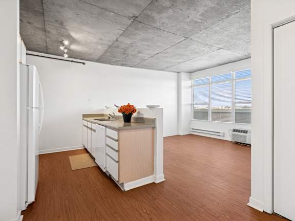 A kitchen with white cabinets and a refrigerator.