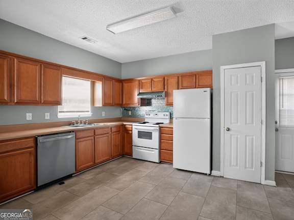 A kitchen with brown cabinets and white appliances.