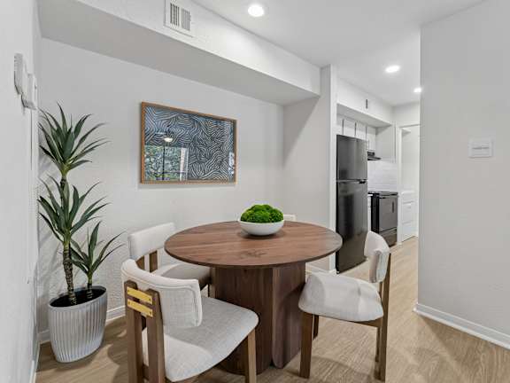 A dining room with a wooden table and chairs.