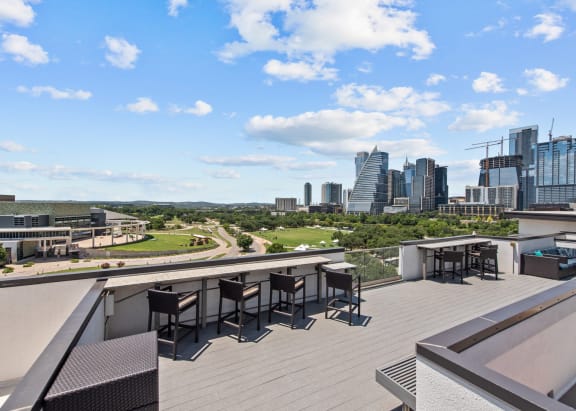 a balcony with tables and chairs and a view of the city