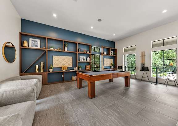 A room with a pool table and a couch.
