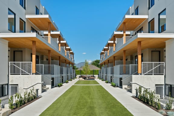 a grassy area in the middle of a row of apartment buildings