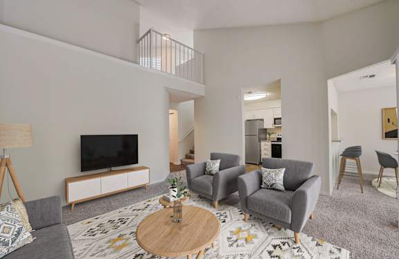 A living room with a grey couch, a wooden coffee table, and a television.