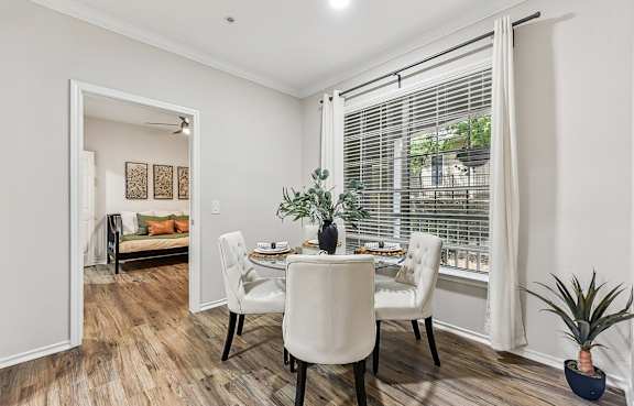 A dining room with a glass table and white chairs. at Stone Oak @ Parmer, Austin, TX