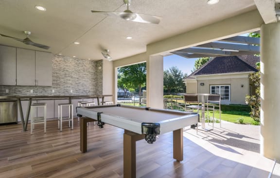 a patio with a pool table and a bar