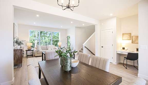 A modern dining room with a wooden table and chairs.