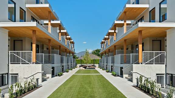 a grassy area in the middle of a row of apartment buildings