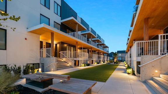 an apartment building with a lot of stairs and green grass