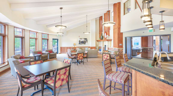 a large lobby with tables and chairs and a kitchen
