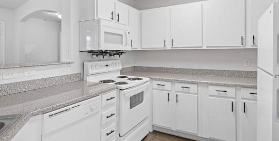 an open kitchen and living room with white cabinets and black appliances