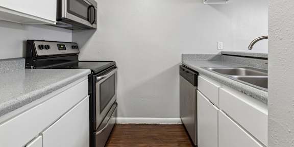 A kitchen with white cabinets and a black stove top oven.