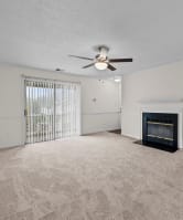 the living room has a fireplace and a ceiling fan