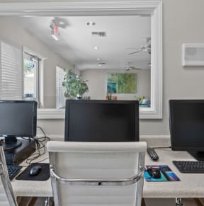 a computer lab with three computer monitors and a keyboard and mouse