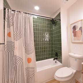 A bathroom with a toilet, sink, and shower.
