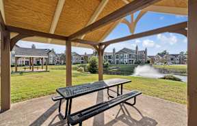 a park with a fountain and benches in the grass