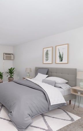 A bedroom with a large bed and a chair. at The Alpine Apartments, Kettering, 45429