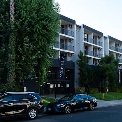 an apartment building with cars parked in front of it